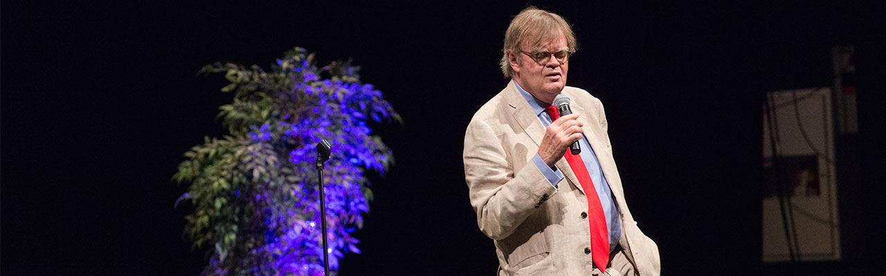WCU Live - main on stage holding a microphone