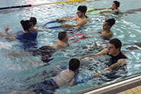 Students helping children to swim