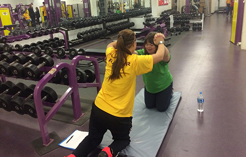 Student assisting a child perform an exercise