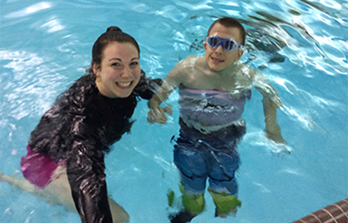 Student and a boy smiling in a pool