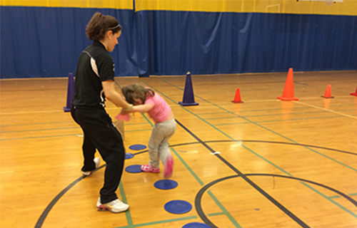 Student assisting a child play a game