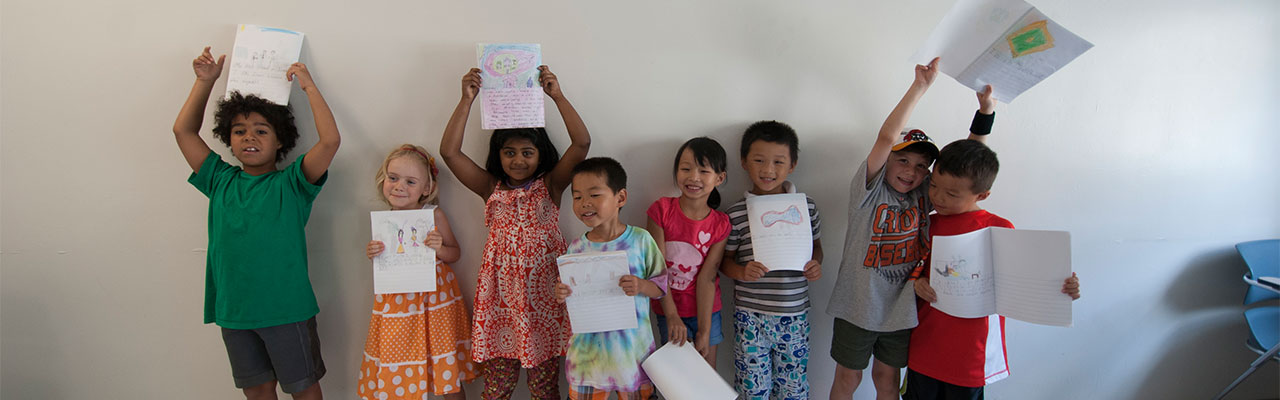 Young Readers and Writers holding up signs