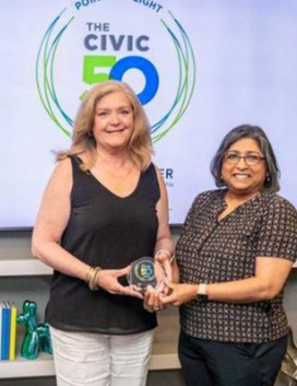 Helen Hammerschmidt and Rita Patel-Eng receive Civic50 award standing in front of Civic50 banner