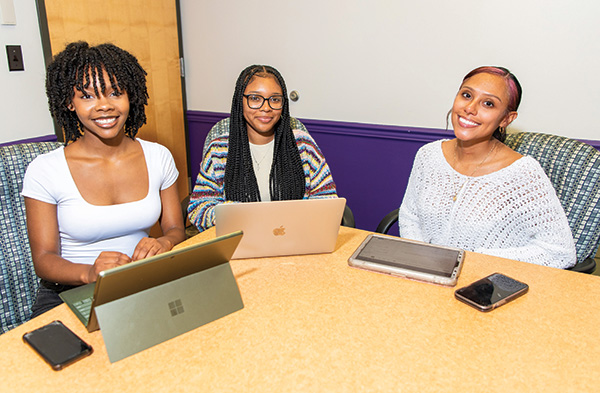 3 females students sitting as the student board