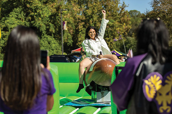 A young woman is pictured having a fun time on the football mechanical bull ride