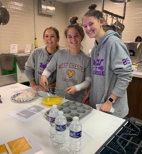 West Chester University (WCU) student-athletes from the women’s lacrosse team are pictured in the Food Lab enjoying a healthy cooking demonstration presented recently by the Student-Athlete Sports Nutrition Education and Fueling Program.
