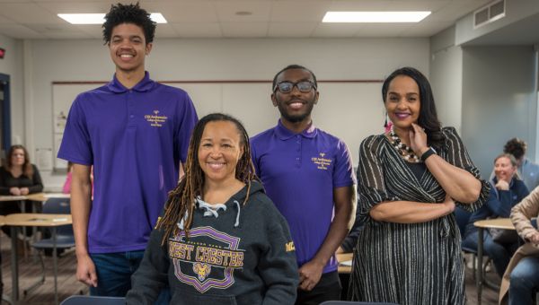 Dr. Desha Williams (center), dean of West Chester University’s College of Education and Social Work, is pictured at Plymouth Whitemarsh High School with recent WCU education graduates/former PRIZE Ambassadors Devin Davis (back row/left), Imere Williams (back row/middle), and Equity and Advancement Officer for Colonial School District Melissa Figueroa-Douglas (back row/right).