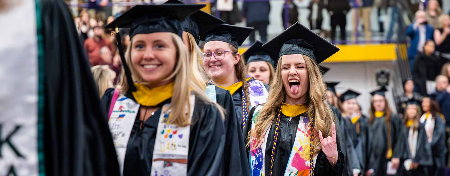 Photo of excited students walking into graduation