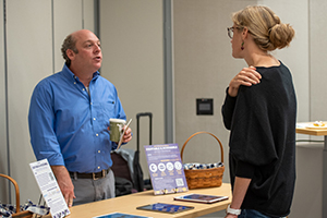 two people standing around table talking