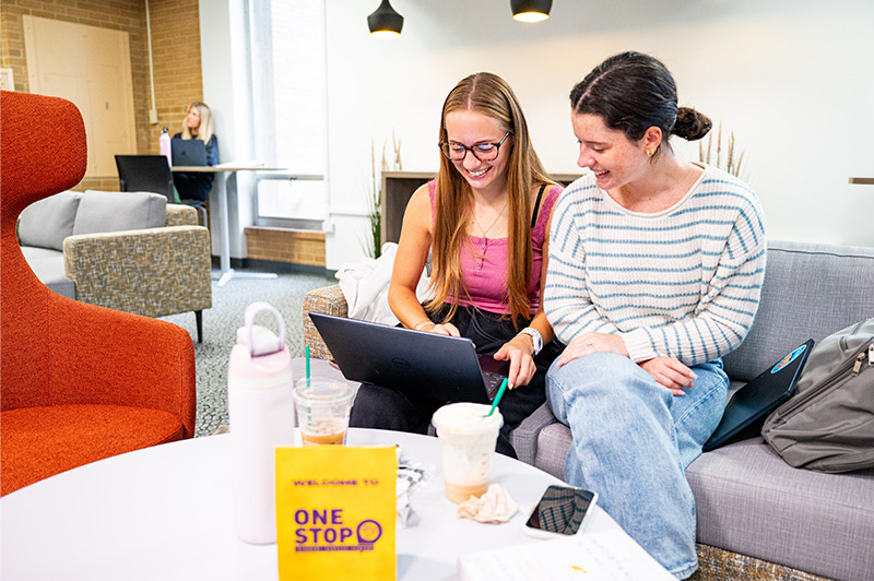 Two students studying on a couch