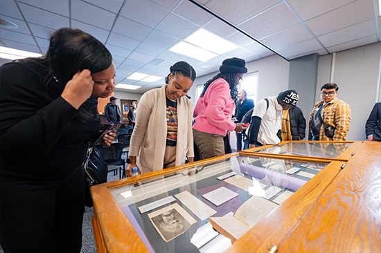 Candid photo from the Frederick Douglass day event. Patrons looking at frederick douglass material. 